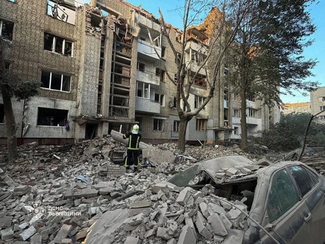 Рятувальник біля уламків на місці влучання в багатоповерхівку у Львові вночі 30 липня 2026 року